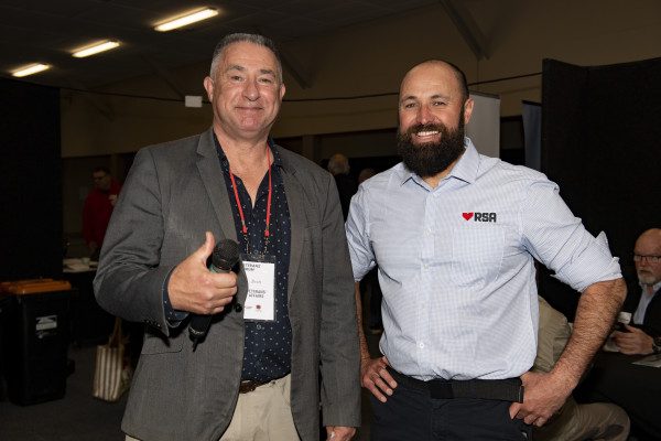 A Veterans' Affairs staff member giving a thumbs up next to a smiling RNZRSA member